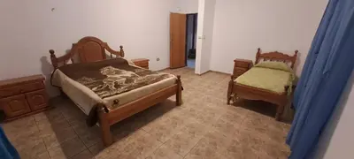 a bedroom with two twin beds and a chair at Posada Los Cerros in Luján