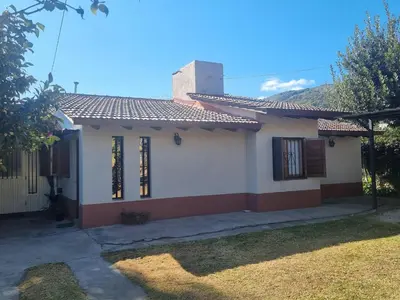 a small white house with a red roof at Las Camelias - chalet zona centro, aerosillas in Villa Carlos Paz