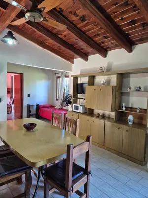 a kitchen and living room with a table and chairs at Las Camelias - chalet zona centro, aerosillas in Villa Carlos Paz