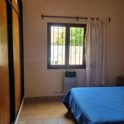 a bedroom with a blue bed and a window at Las Camelias - chalet zona centro, aerosillas in Villa Carlos Paz