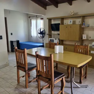a dining room with a wooden table and chairs at Las Camelias - chalet zona centro, aerosillas in Villa Carlos Paz