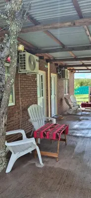 a patio with a table and chairs and a tree at Ares cabaña de campo- Rincón de Afrodita in San Lorenzo