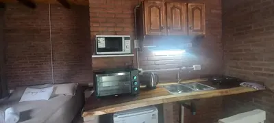 a kitchen with a counter with a microwave and a sink at Ares cabaña de campo- Rincón de Afrodita in San Lorenzo