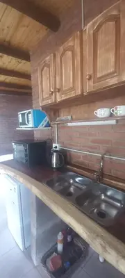 a kitchen with a sink and wooden cabinets at Ares cabaña de campo- Rincón de Afrodita in San Lorenzo