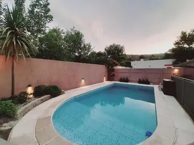 a swimming pool in a yard next to a fence at Rincón de sol y rio in Villa Carlos Paz