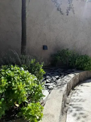 a garden with a stone path and plants at Rincón de sol y rio in Villa Carlos Paz