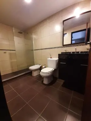a bathroom with two toilets and a sink and a mirror at Rincón de sol y rio in Villa Carlos Paz