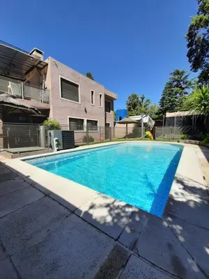 a swimming pool in front of a house at Rincón de sol y rio in Villa Carlos Paz