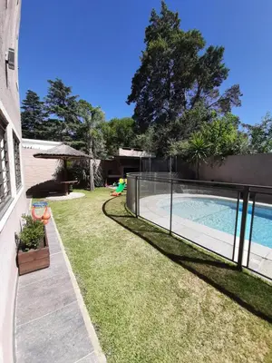 a backyard with a swimming pool and a fence at Rincón de sol y rio in Villa Carlos Paz