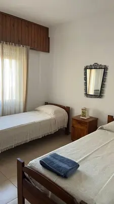 a bedroom with two beds and a mirror on the wall at departamento moreno151 in Villa Carlos Paz
