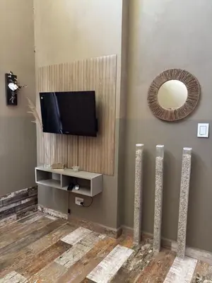 a living room with a television and a mirror at Casa de verano confortable in Villa de Las Rosas