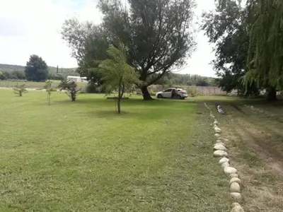 a stone path in a field with a car in the background at Casa de verano confortable in Villa de Las Rosas