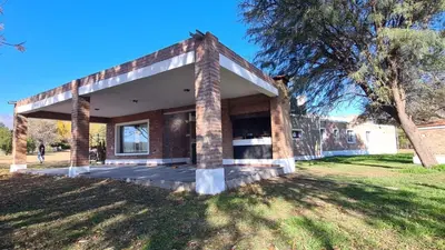 a brick house in a park with a tree at Casa de verano confortable in Villa de Las Rosas