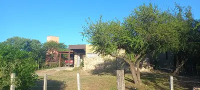 a house with a tree and a fence at Casa Despertares - Las Rabonas in Mina Clavero