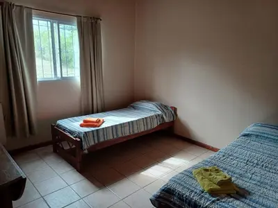 a bedroom with two twin beds and a window at Casa Despertares - Las Rabonas in Mina Clavero