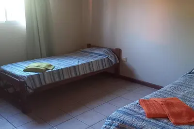 a room with two twin beds and a window at Casa Despertares - Las Rabonas in Mina Clavero