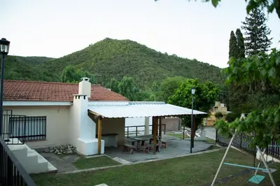 a house with a patio with a mountain in the background at Silencio Dorado in Villa Serranita