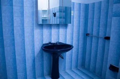 a blue bathroom with a sink and a mirror at Silencio Dorado in Villa Serranita