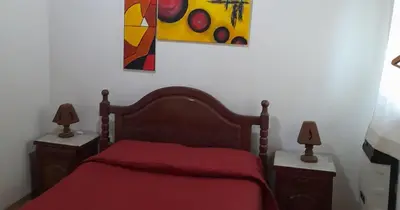 a bedroom with a red bed with two night stands at Cabañas La Petunia in Santa Rosa de Calamuchita