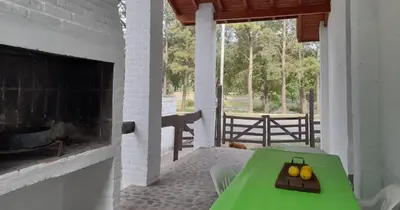 a room with a green table with fruit on it at Cabañas La Petunia in Santa Rosa de Calamuchita