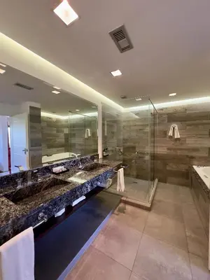 a bathroom with two sinks and a glass shower at Neper Hotel in Cordoba