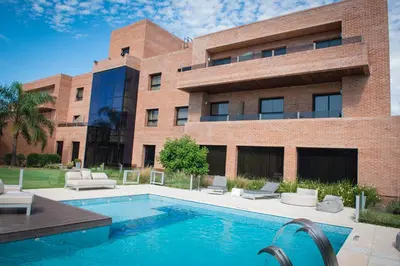 a building with a swimming pool in front of a building at Neper Hotel in Cordoba