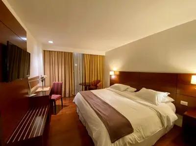 a hotel room with a large bed and a desk at Neper Hotel in Cordoba