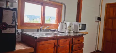 a kitchen counter with a sink and a window at Cima Capri Cabañas in Villa Carlos Paz