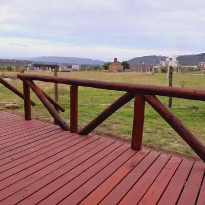 a wooden bench sitting on top of a wooden deck at Cima Capri Cabañas in Villa Carlos Paz