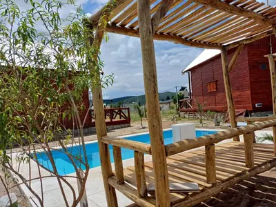 a wooden pergola next to a swimming pool at Cima Capri Cabañas in Villa Carlos Paz