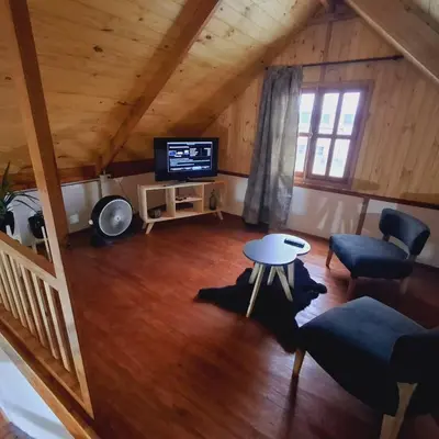 a living room with a tv and a table and chairs at Cima Capri Cabañas in Villa Carlos Paz