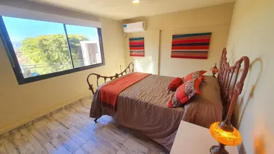 a bedroom with a bed and a large window at La Moradita Villa Carlos Paz in Villa Carlos Paz