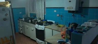 a kitchen with a stove and a blue tiled wall at Chalet de Montaña a 8 cuadras del centro de Carlos Paz con pileta de 9 x 4 in Villa Carlos Paz