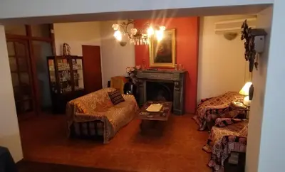 a living room with a fireplace and a couch and a table at Acogedora Casa Familiar en Zona Residencial in Cordoba