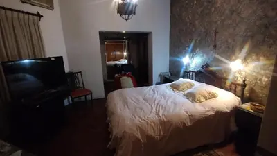 a bedroom with a white bed and a television at Acogedora Casa Familiar en Zona Residencial in Cordoba