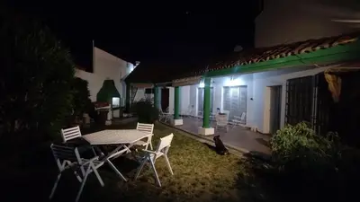 a table and chairs in front of a house at night at Acogedora Casa Familiar en Zona Residencial in Cordoba