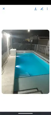 a large blue swimming pool in a building at Monoambiente Cerro in Villa Carlos Paz