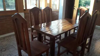 a wooden table and chairs in a room at Cabañas El Conejo Negro in Villa Cura Brochero