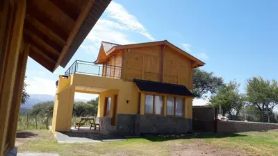 a small house with a balcony on top of it at Cabañas El Conejo Negro in Villa Cura Brochero