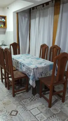 a dining room table and chairs with a blue and white table cloth at Cabañas El Conejo Negro in Villa Cura Brochero