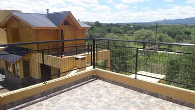 a balcony with a bird cage on top of it at Cabañas El Conejo Negro in Villa Cura Brochero