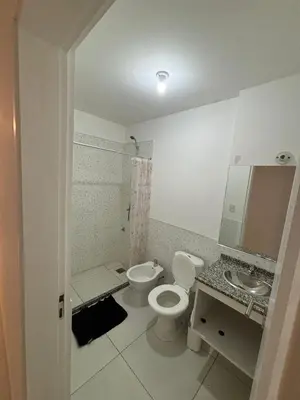 a white bathroom with a toilet and a sink at Departamento para dos personas in Cordoba