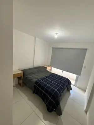 a bedroom with a bed with a blue plaid blanket at Departamento para dos personas in Cordoba