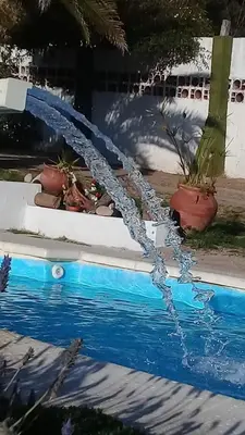 a water hose coming out of a swimming pool at Casa y cabaña de Gachy in Villa Carlos Paz