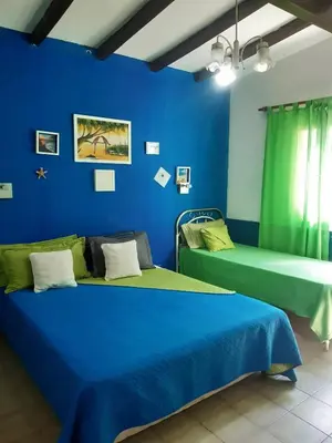 a room with two beds and a blue wall at Casa y cabaña de Gachy in Villa Carlos Paz