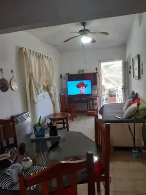 a living room with a table and a television at Casa y cabaña de Gachy in Villa Carlos Paz