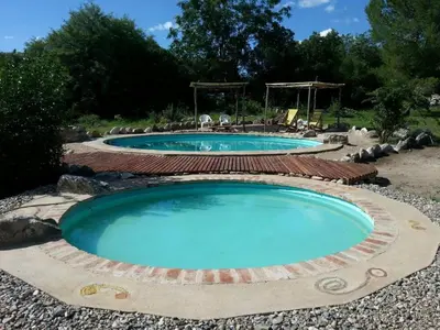 two pools in a landscaping with a stone coping around them at Cielito lindo in San Javier
