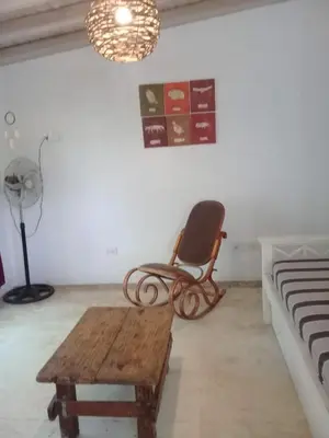 a room with a chair and a table and a lamp at Cielito lindo in San Javier
