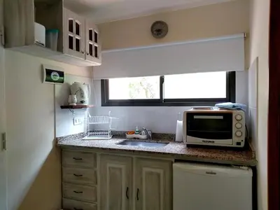 a small kitchen with a microwave and a sink at Dorado del Sol in Merlo