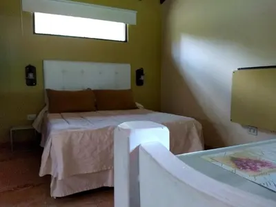 a bedroom with a bed in a room with a window at Dorado del Sol in Merlo
